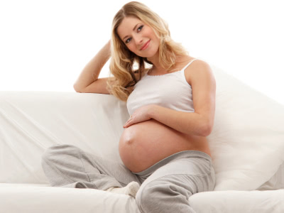 těhotná žena sedí na gauči